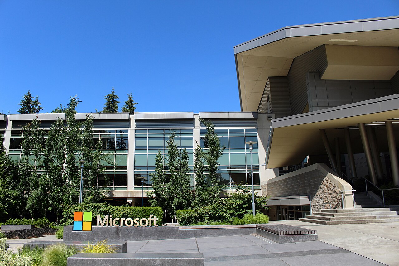 A glass office building with a Microsoft sign in front of it