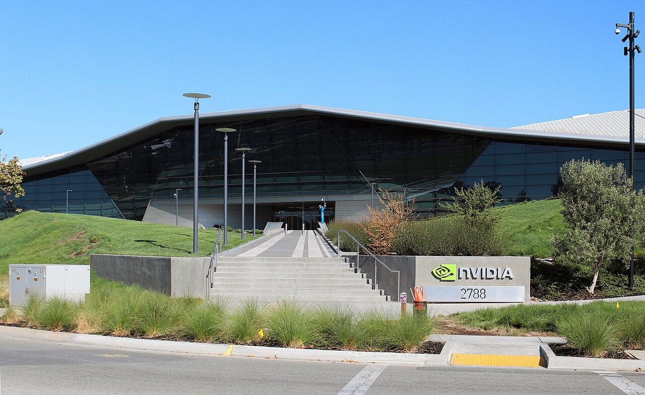 A low building with a sweeping glass front behind a sign with the Nvidia logo